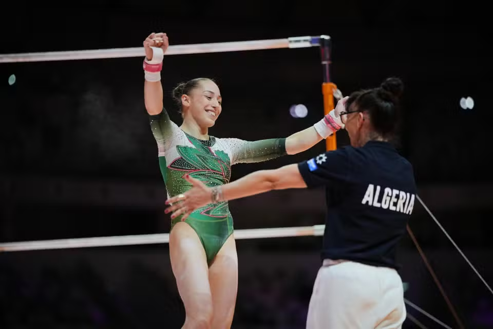 Kaylia Nemour, avec son entraîneuse Nadia Massé, à l’issue de la finale des barres asymétriques des championnats du monde de gymnastique artistique, à Djakarta, en Indonésie, le 24 octobre 2025. DITA ALANGKARA / AP