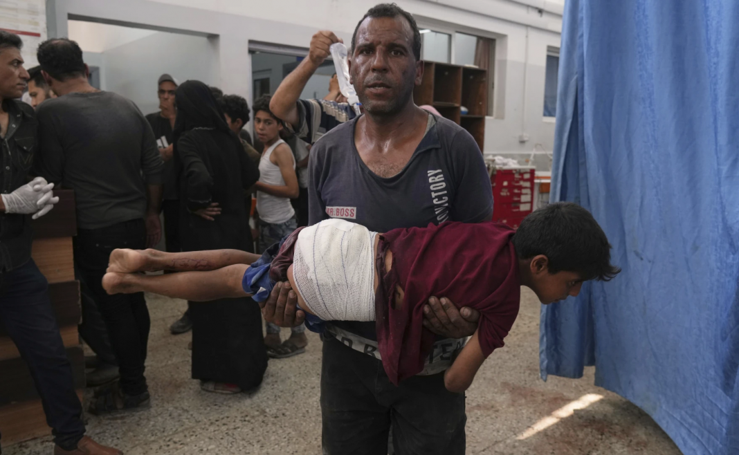 Un homme porte un enfant blessé lors d'une frappe israélienne, hôpital Shifa, dans la ville de Gaza, Archive juin 2025. Photo Jehad Alshrafi / AP